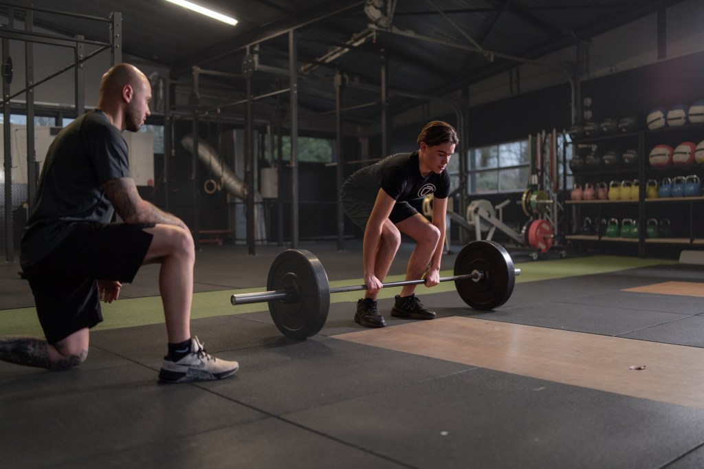 Expert personal trainer guiding a client through a customized workout for targeted fitness goals. At Cluster Zuid | Driven By Sports.